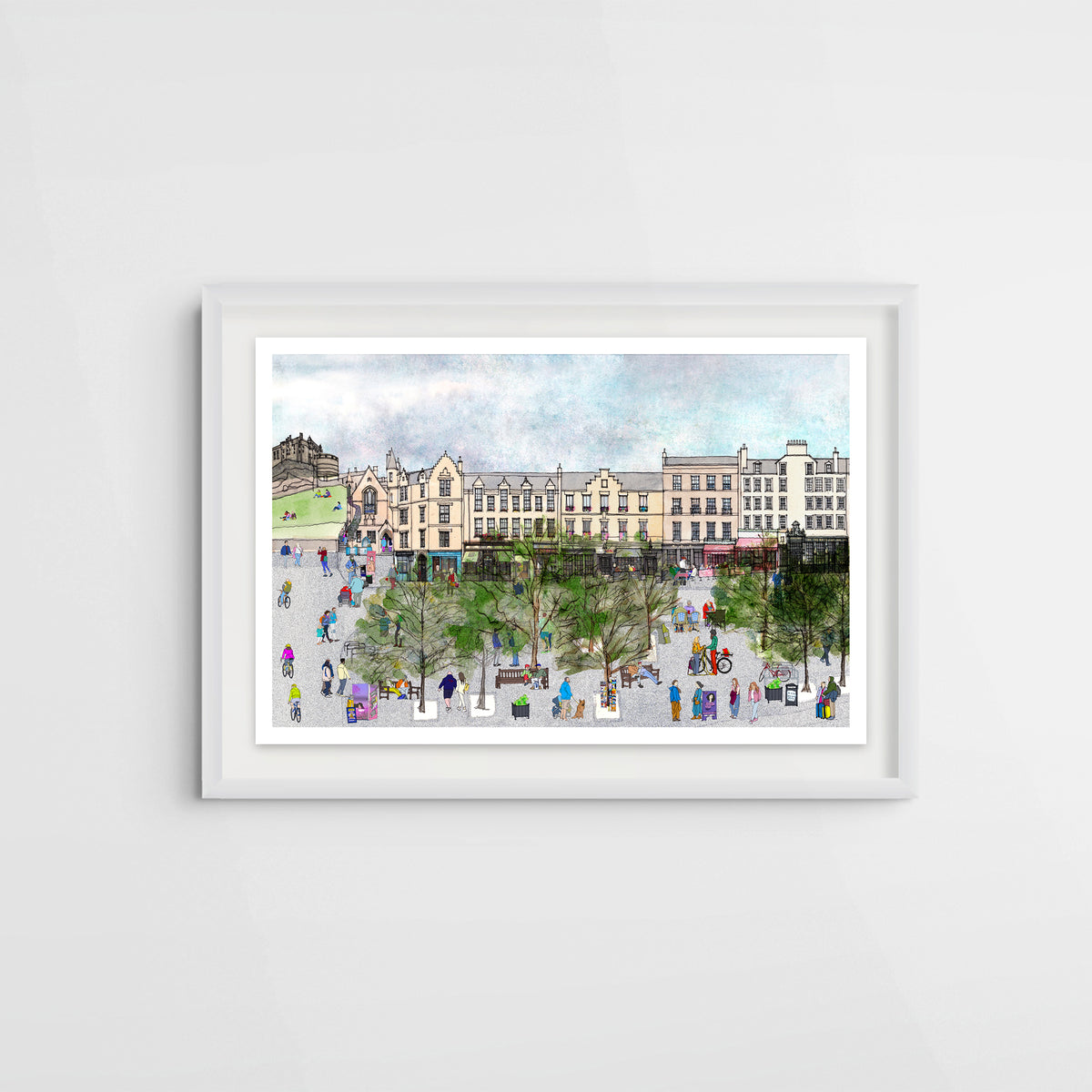 A framed watercolour art print depicting the bustling city square of Edinburgh's Grassmarket with historic buildings, trees, and small illustrated people, displayed on a light grey wall.