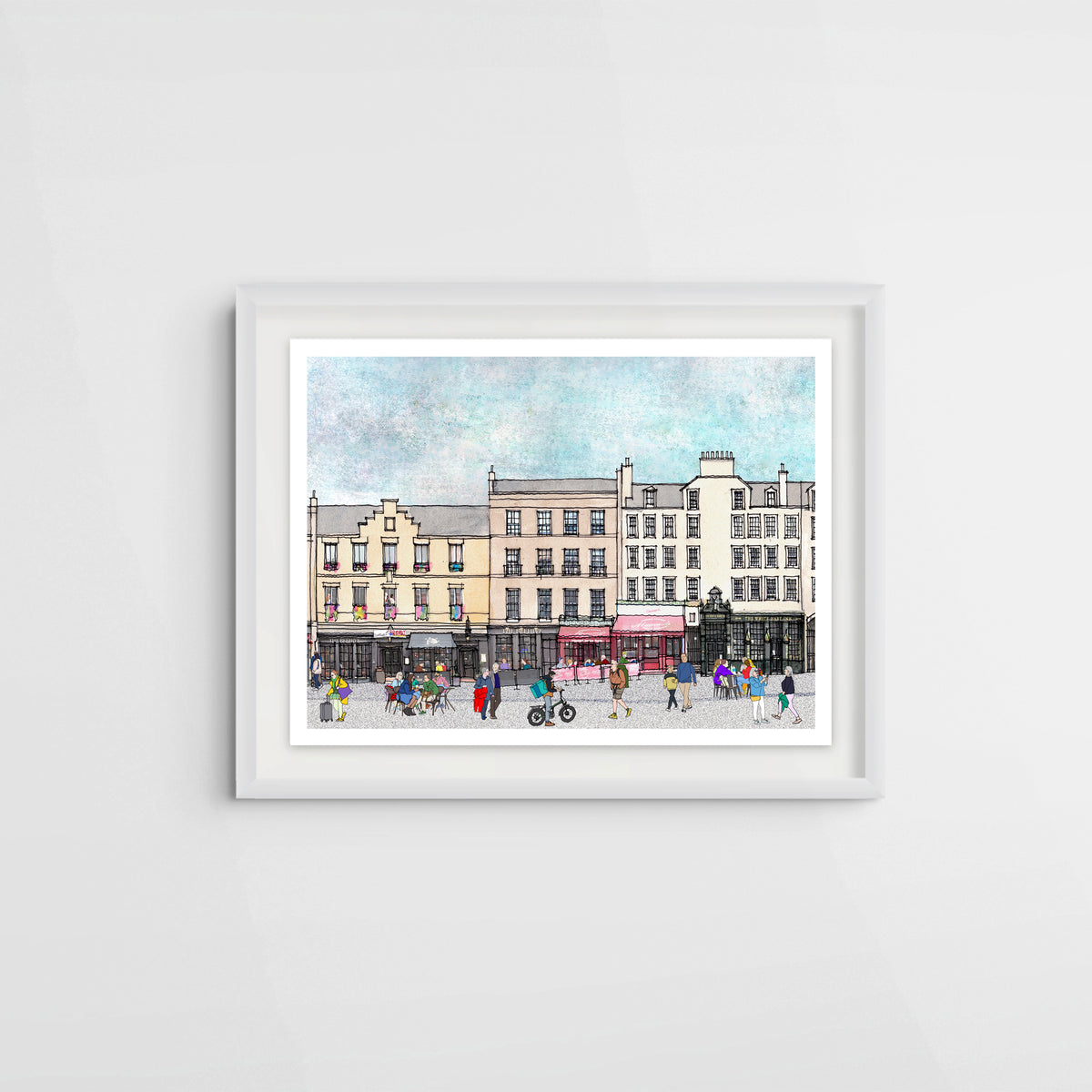 A framed watercolour print of a street scene in Edinburgh's Grassmarket, featuring multi-story tenement buildings, pedestrians, and a red canopy over Mamma's pizza restaurant, displayed on a light grey wall.