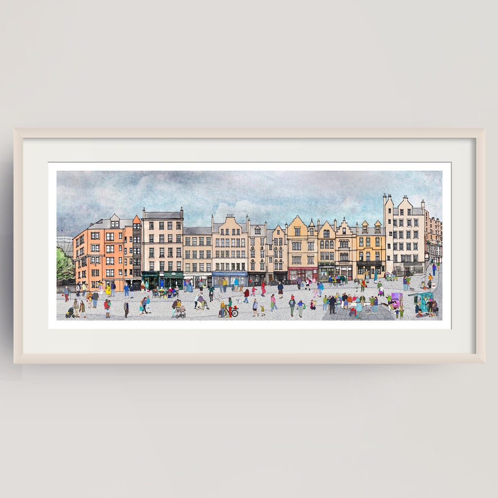 A framed panoramic watercolour print of the bustling city square of Edinburgh's Grassmarket with historic buildings and many small figures, displayed on a light grey wall.
