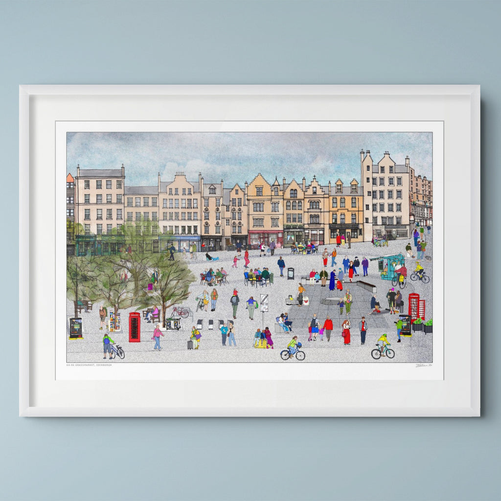 A framed art print depicting a colourful, whimsical scene set during the Edinburgh Festival with people, bicycles, and historic buildings, presented in a white frame against a light blue-grey wall.